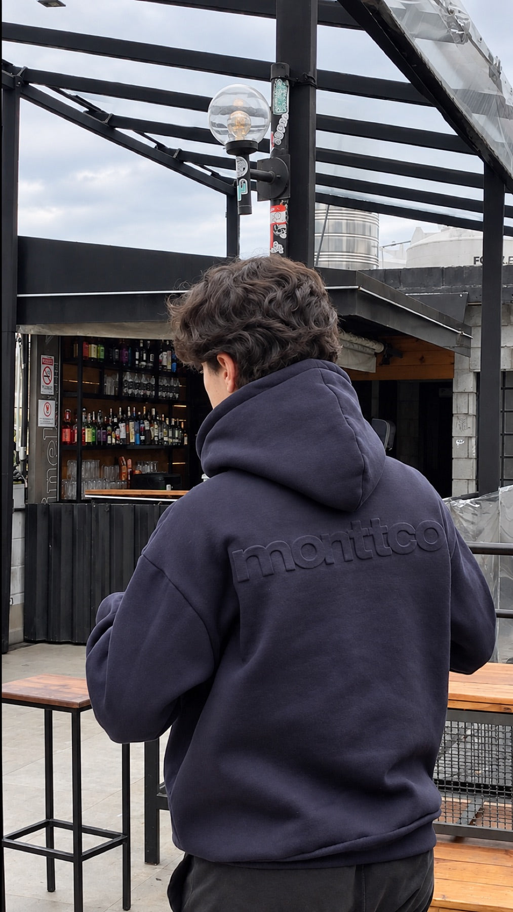 Pessoa de moletom MONTTCO em um bar