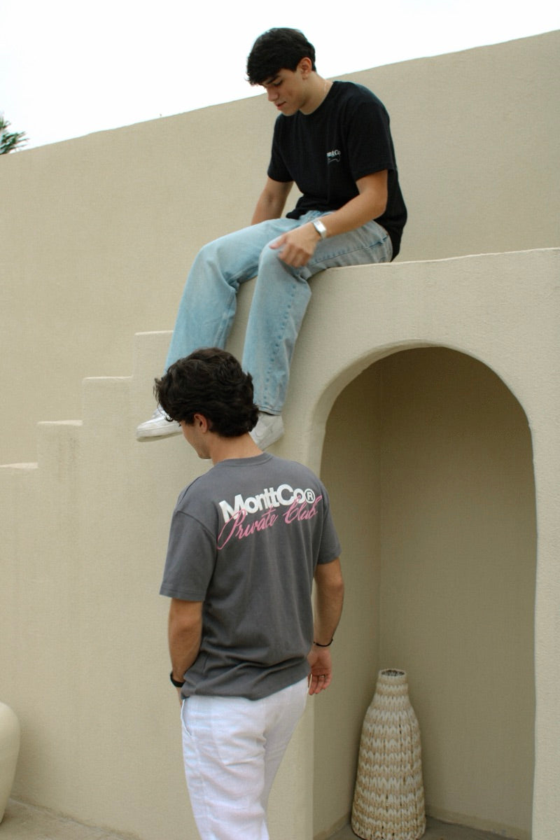 Dois rapazes sentados em um muro